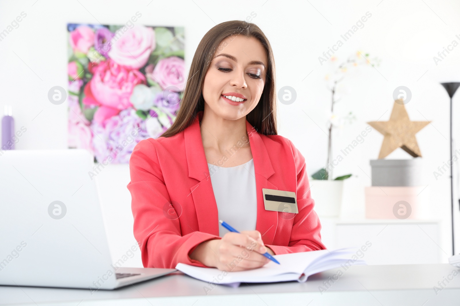 Photo of Beauty salon receptionist with notebook at desk