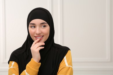 Photo of Beautiful Muslim woman wearing black hijab indoors