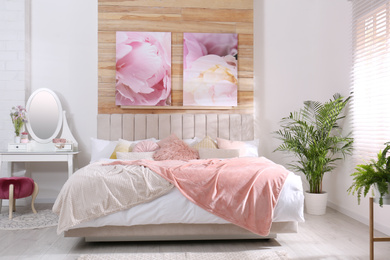 Photo of Stylish room interior with large comfortable bed and beautiful paintings