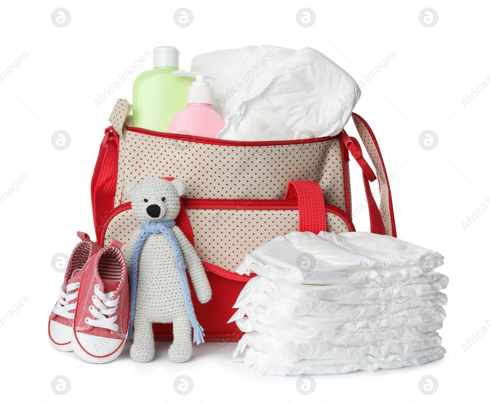 Photo of Maternity bag with disposable diapers and child's accessories on white background