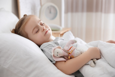 Photo of Cute little girl sleeping with toy at home. Bedtime schedule
