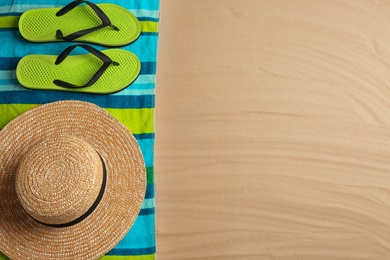 Different beach accessories on sand, flat lay. Space for text