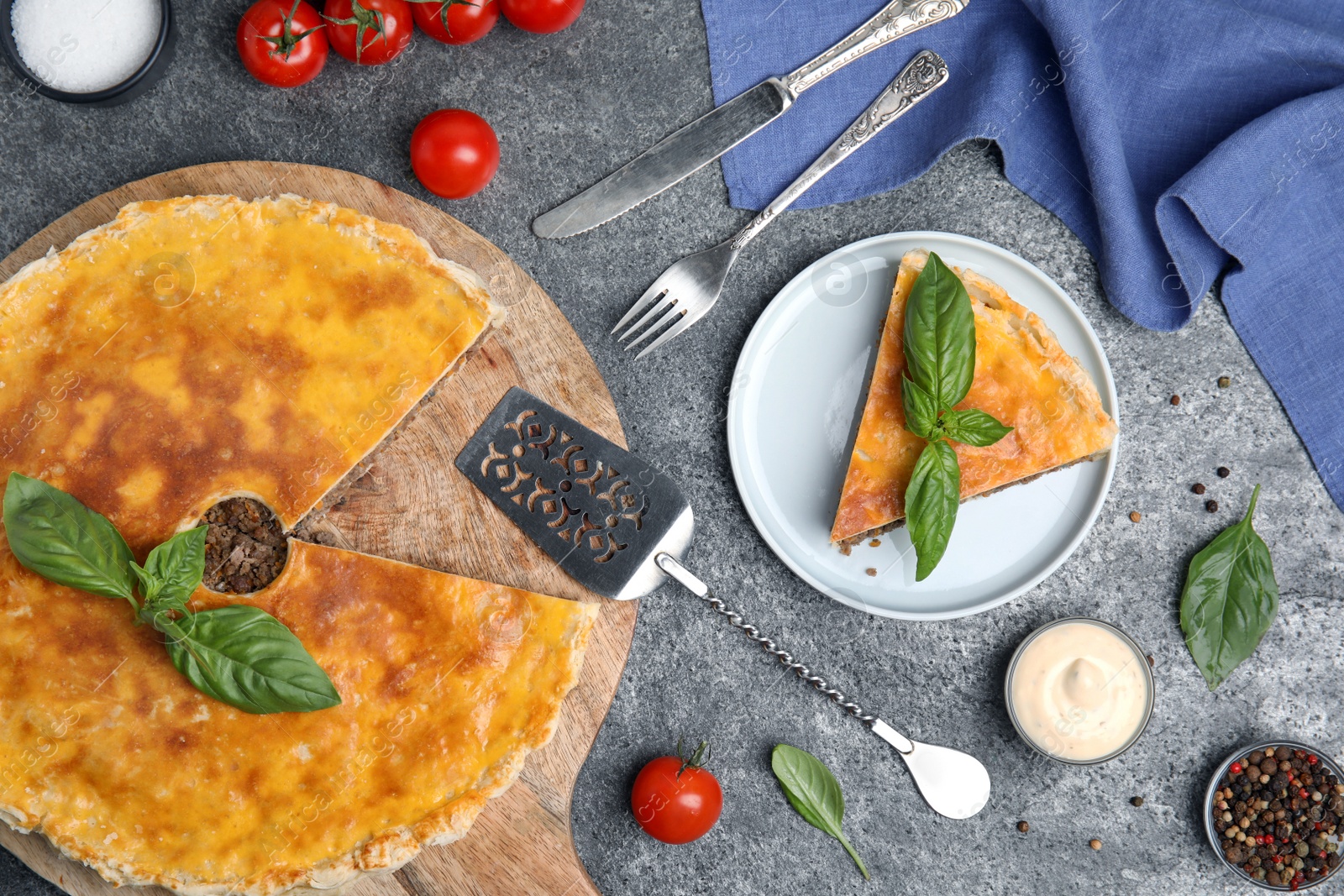 Photo of Delicious pie with minced meat served on grey table, flat lay