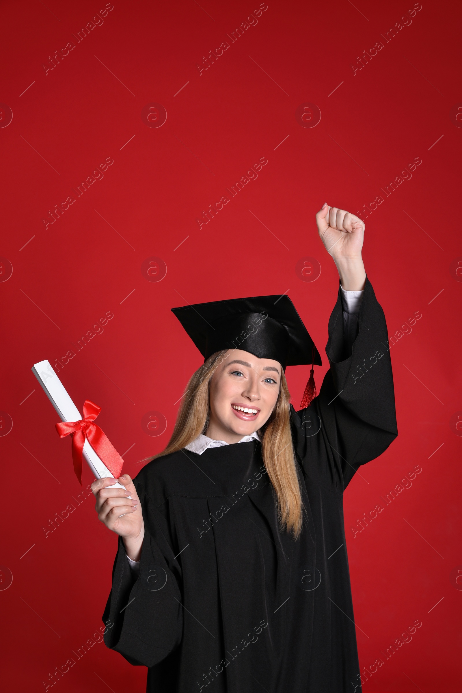 Photo of Happy student with diploma on red background