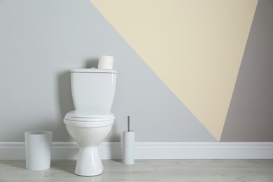 Photo of Simple bathroom interior with new toilet bowl near color wall. Space for text