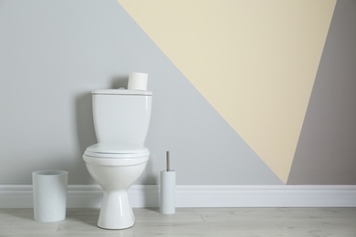 Simple bathroom interior with new toilet bowl near color wall. Space for text