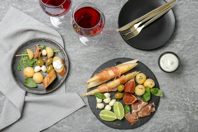 Photo of Flat lay composition with melon and prosciutto appetizer served on table