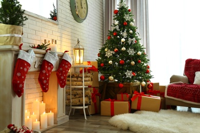 Photo of Stylish interior with beautiful Christmas tree and decorative fireplace