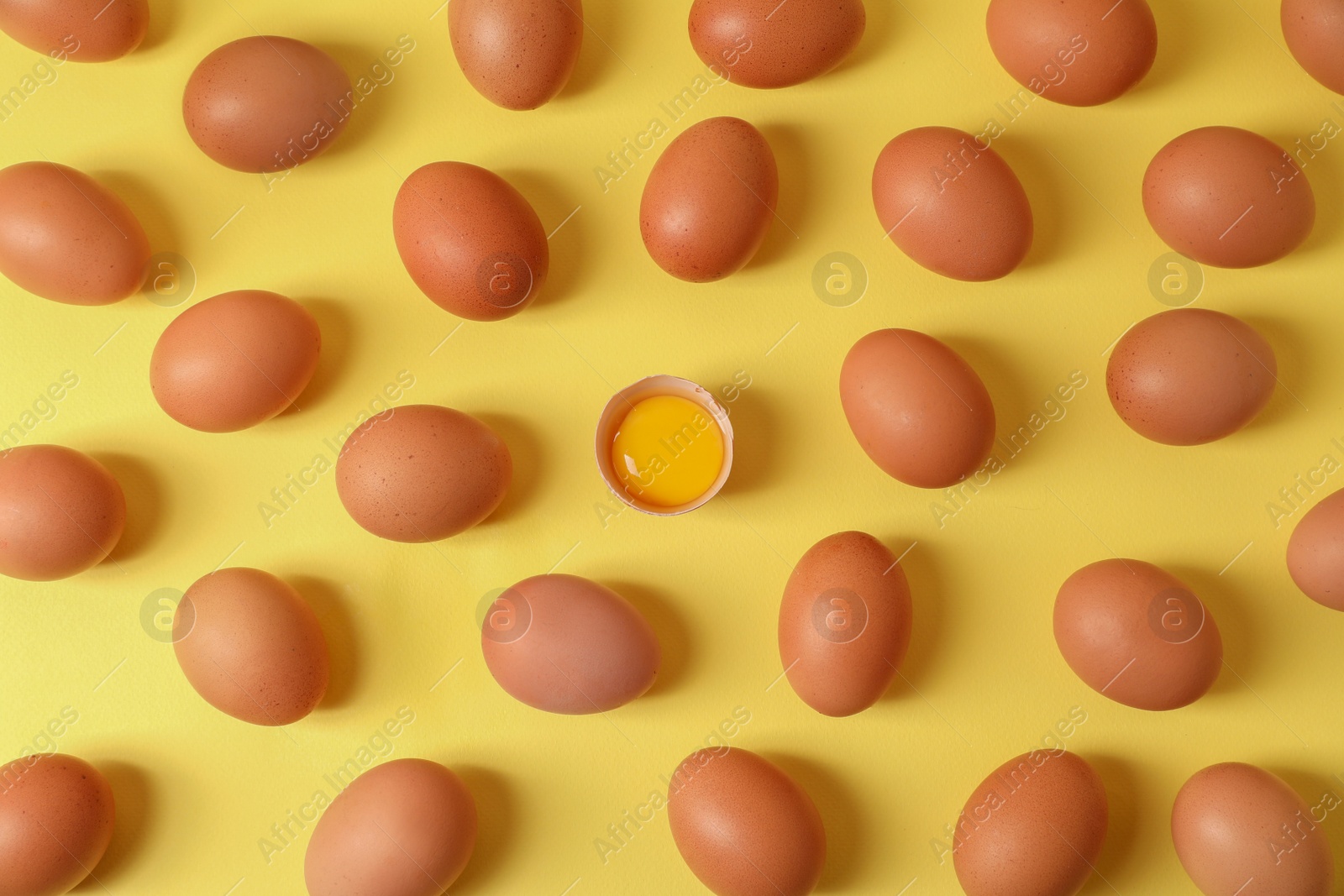 Photo of Fresh chicken eggs on yellow background, flat lay