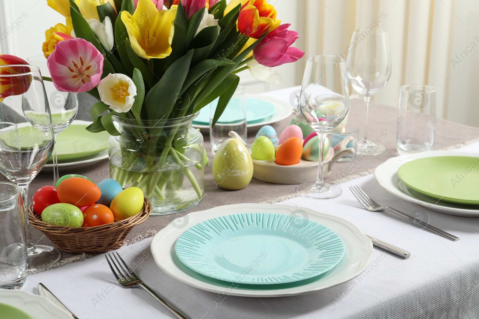 Photo of Easter celebration. Festive table setting with beautiful flowers and painted eggs