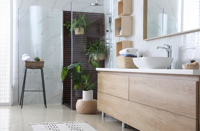 Photo of Bathroom interior with shower stall, counter and houseplants. Idea for design