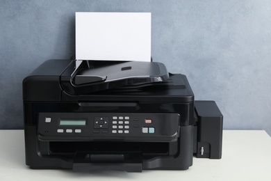 Photo of Modern printer with paper on white table