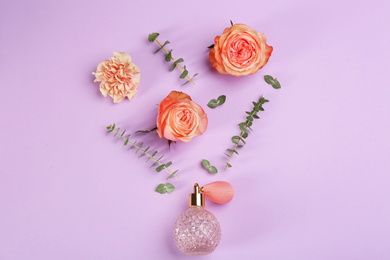 Photo of Beautiful flat lay composition with bottle of perfume, eucalyptus and flowers on lilac background