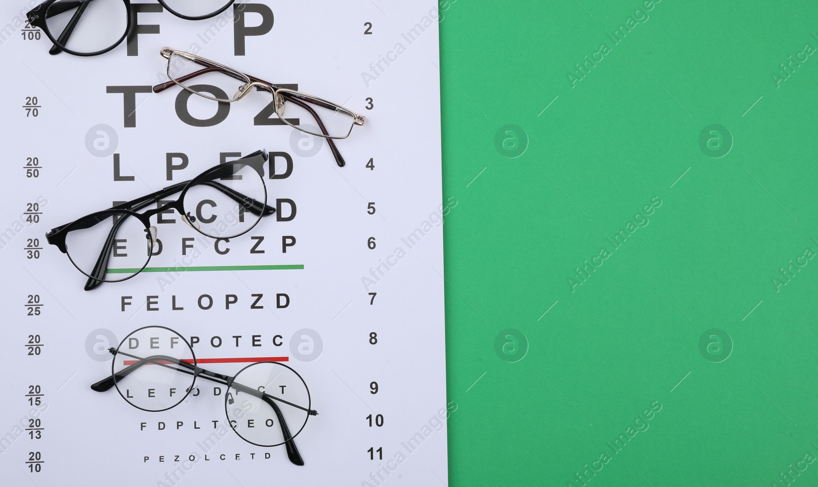 Photo of Vision test chart and glasses on green background, flat lay. Space for text