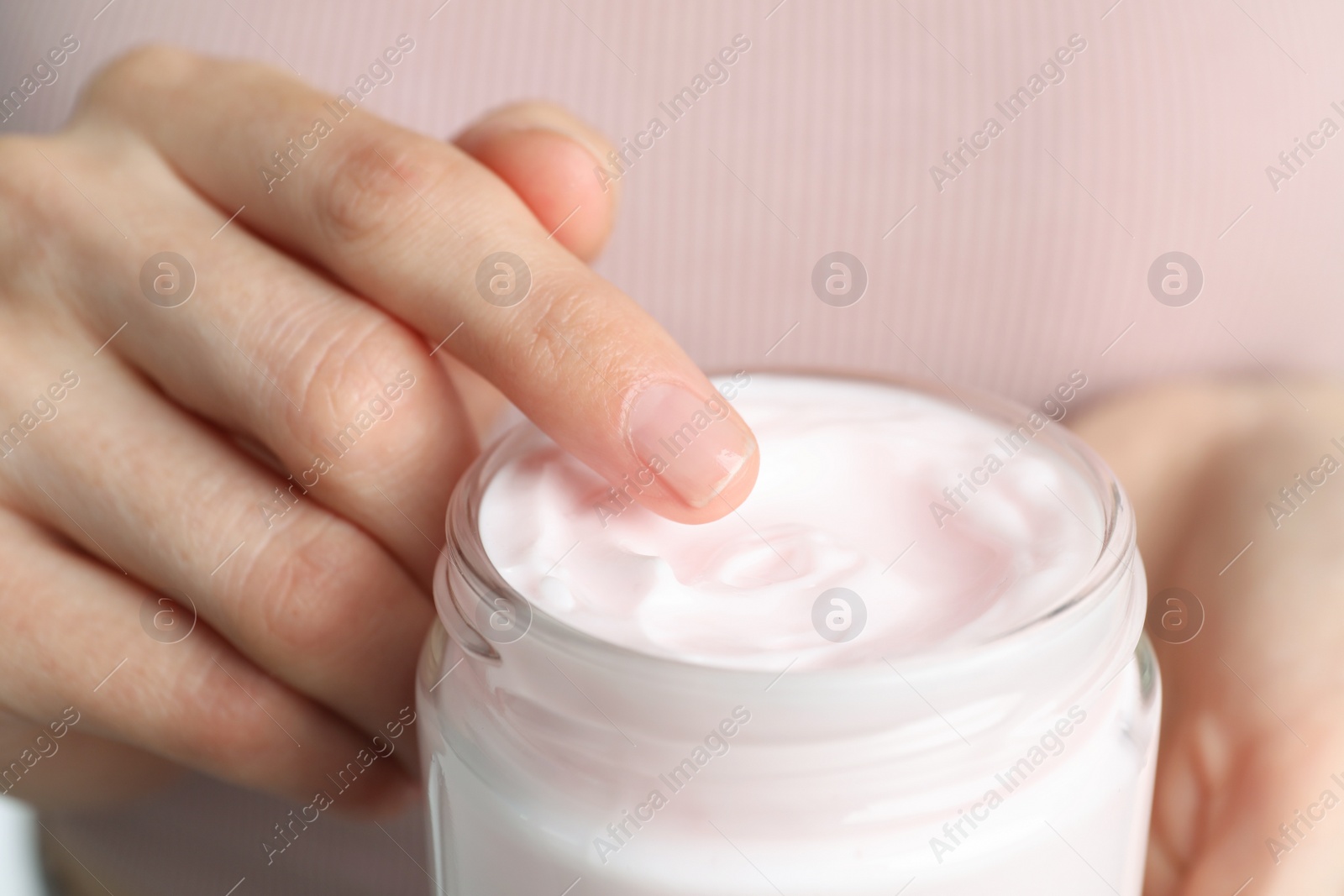 Photo of Woman holding jar of hand cream, closeup