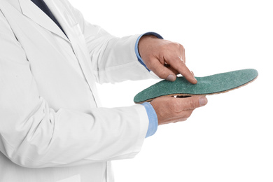 Photo of Male orthopedist showing insole on white background, closeup