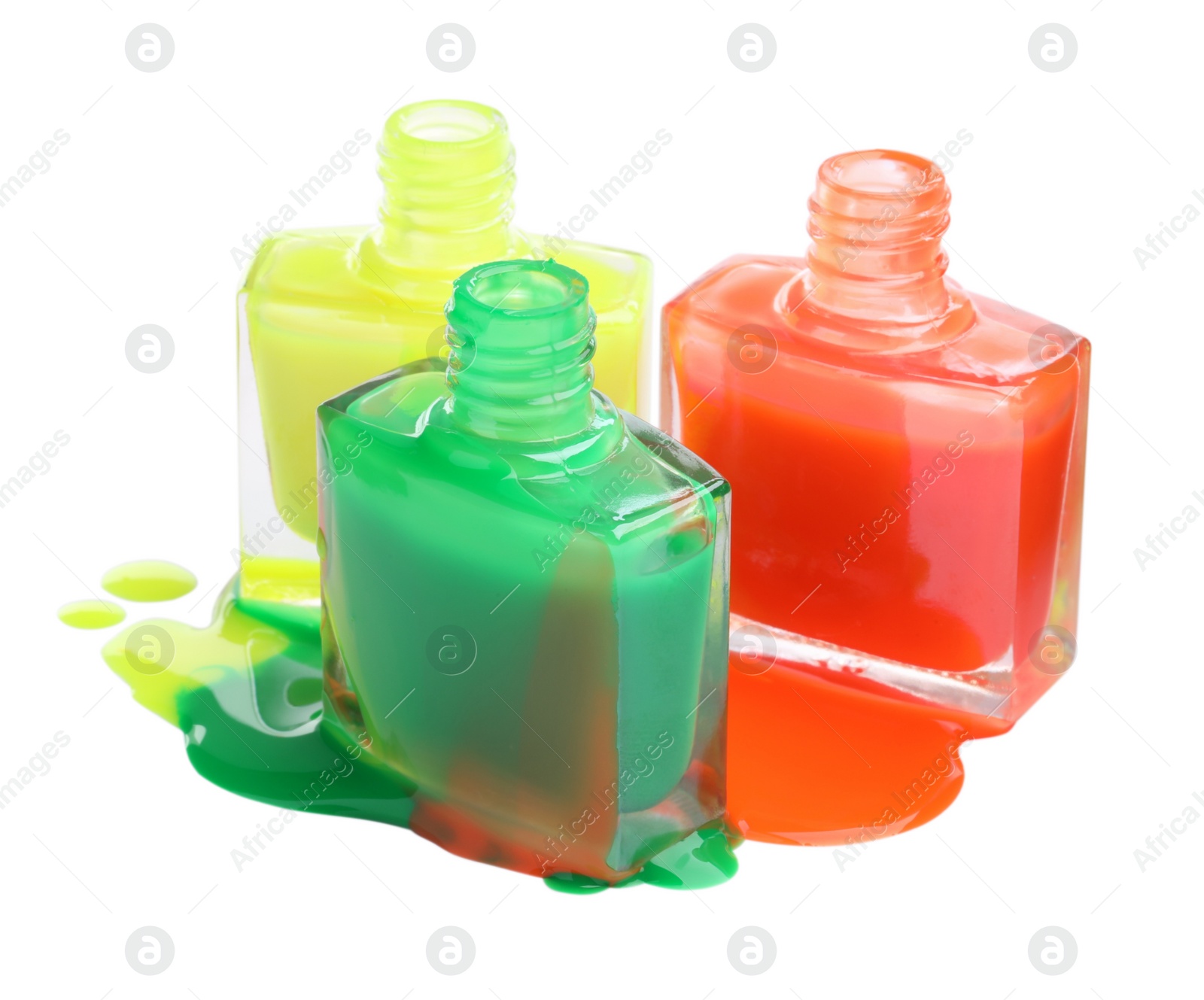 Photo of Puddle of different bright nail polishes and bottles isolated on white