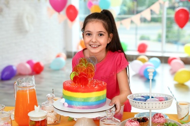 Photo of Happy girl in room decorated for birthday party