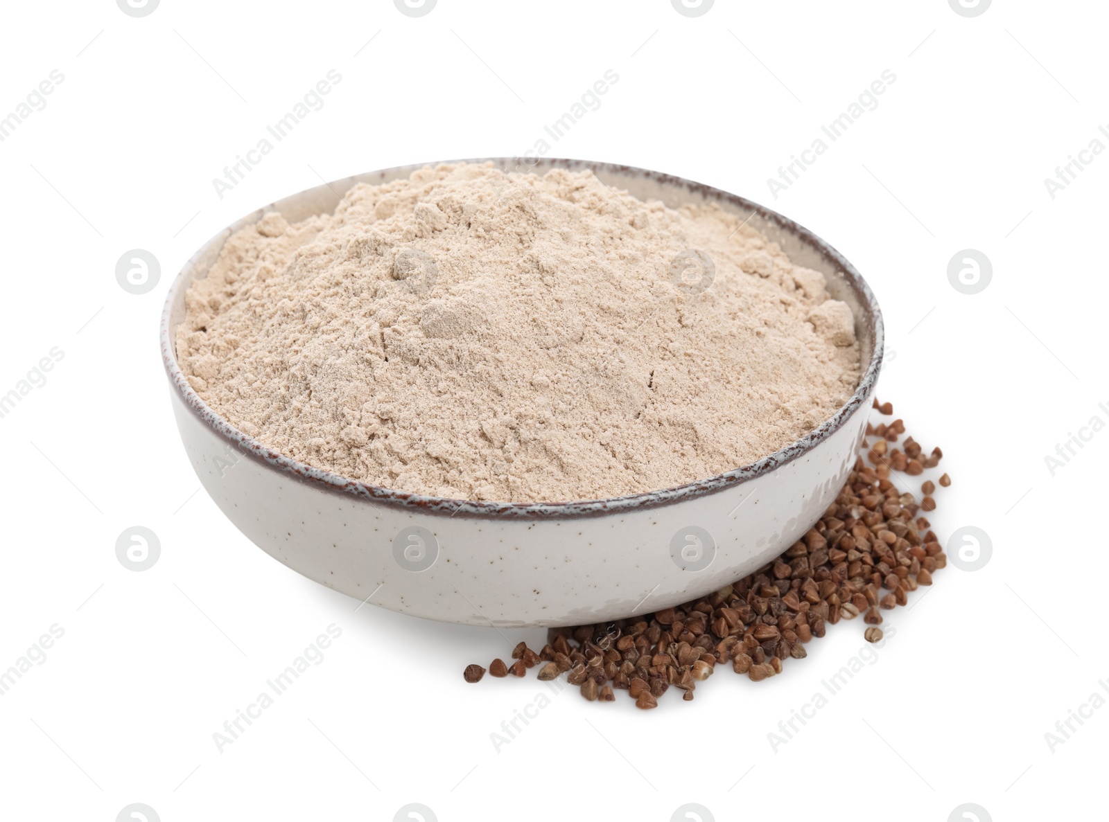 Photo of Bowl with buckwheat flour and grains on white background