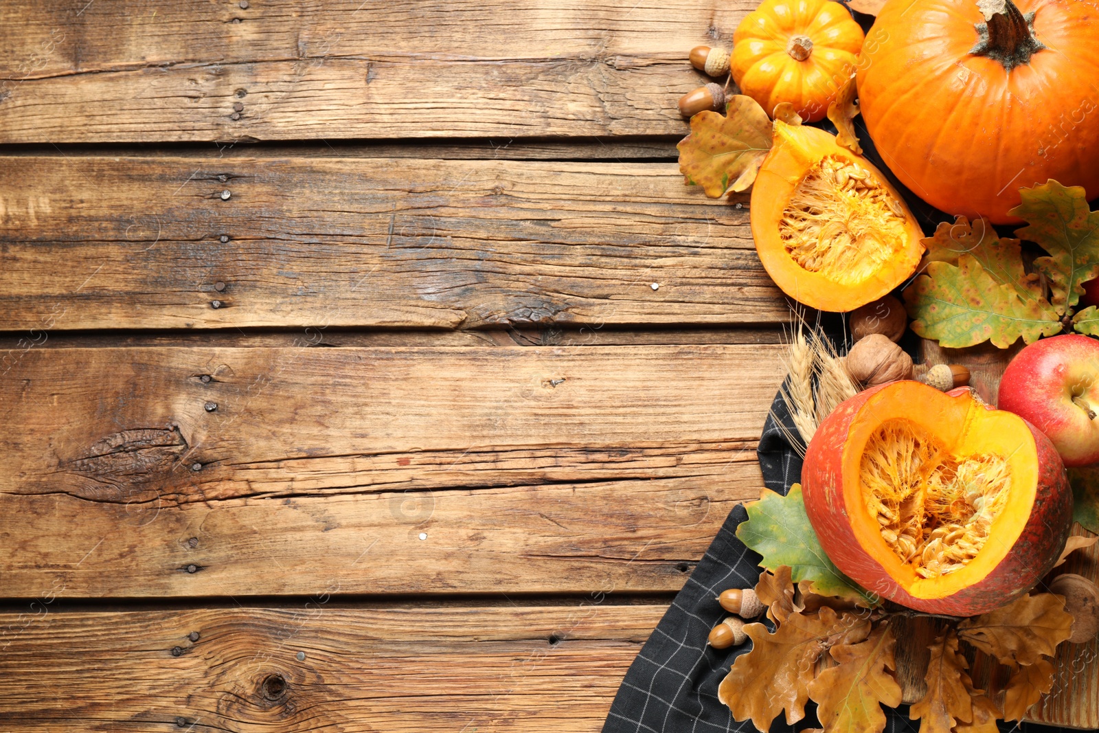 Photo of Flat lay composition with vegetables, nuts and autumn leaves on wooden table, space for text. Thanksgiving Day