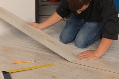 Professional worker installing new laminate flooring, closeup