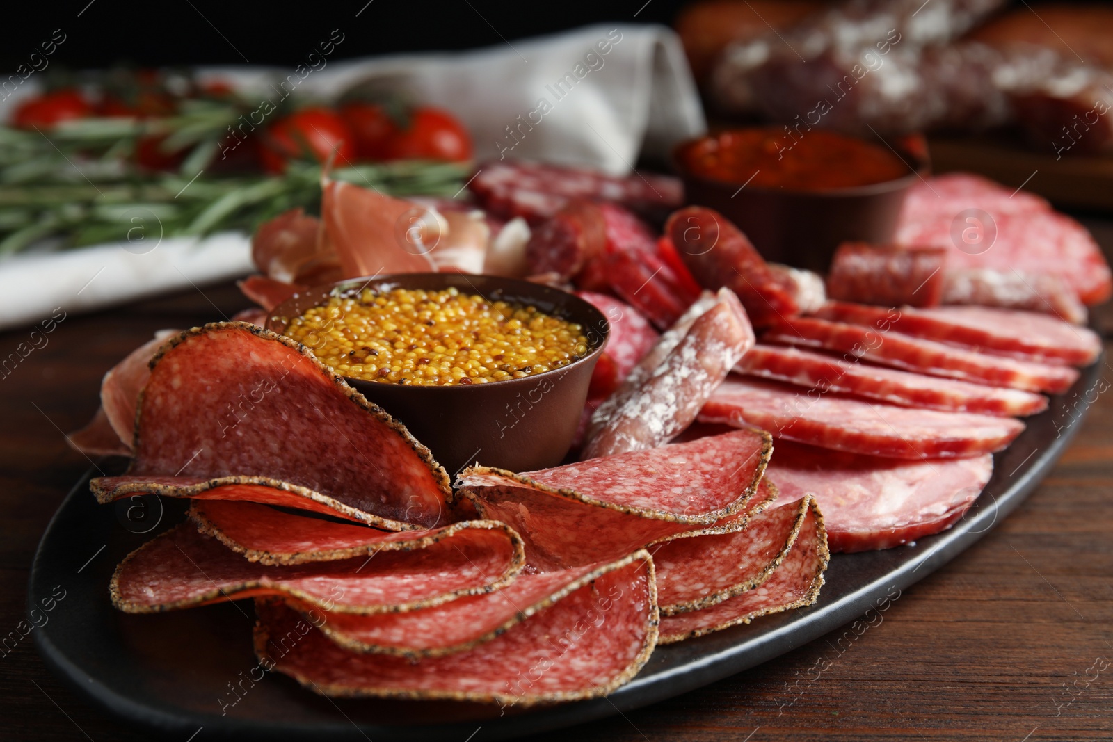 Photo of Different types of sausages with mustard served on wooden table, closeup