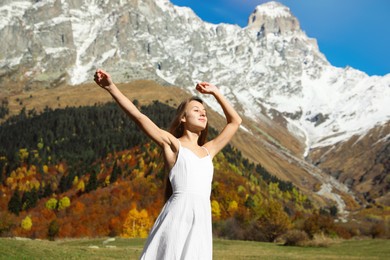 Photo of Young woman walking in beautiful mountains on sunny day