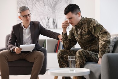 Photo of Professional psychotherapist working with military man in office