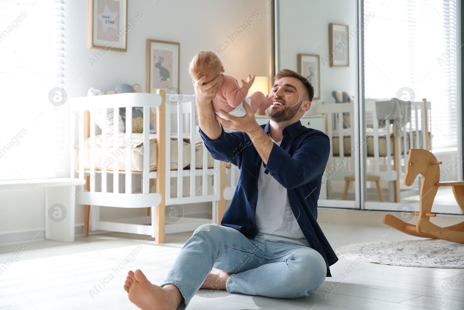 Photo of Father with his newborn son at home