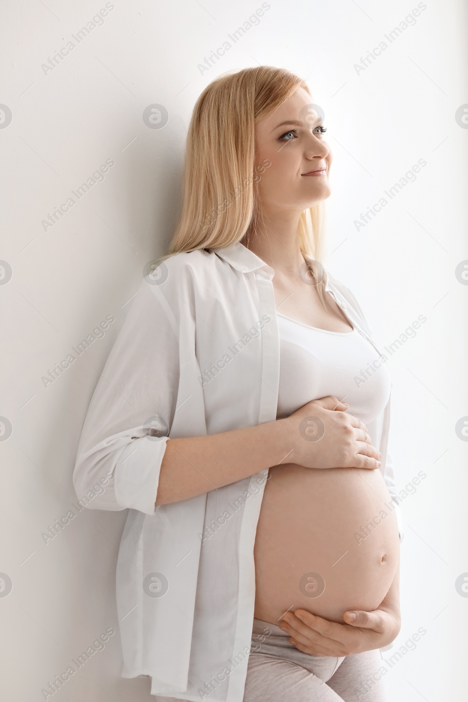 Photo of Portrait of beautiful pregnant woman on light background