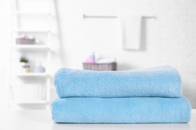 Photo of Stack of fresh towels on table in bathroom. Space for text