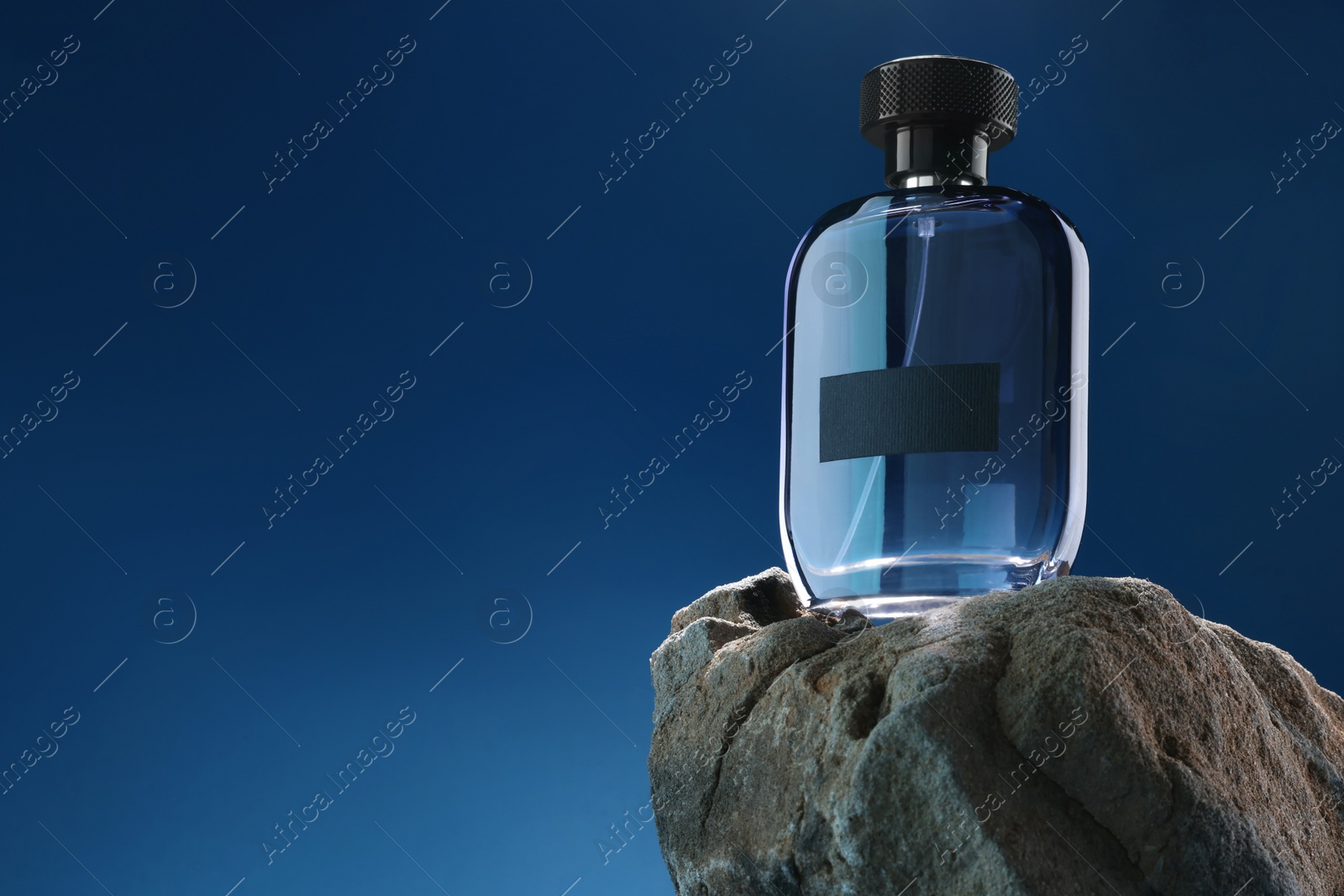 Photo of Stylish presentation of luxury men`s perfume on stone against light blue background. Space for text