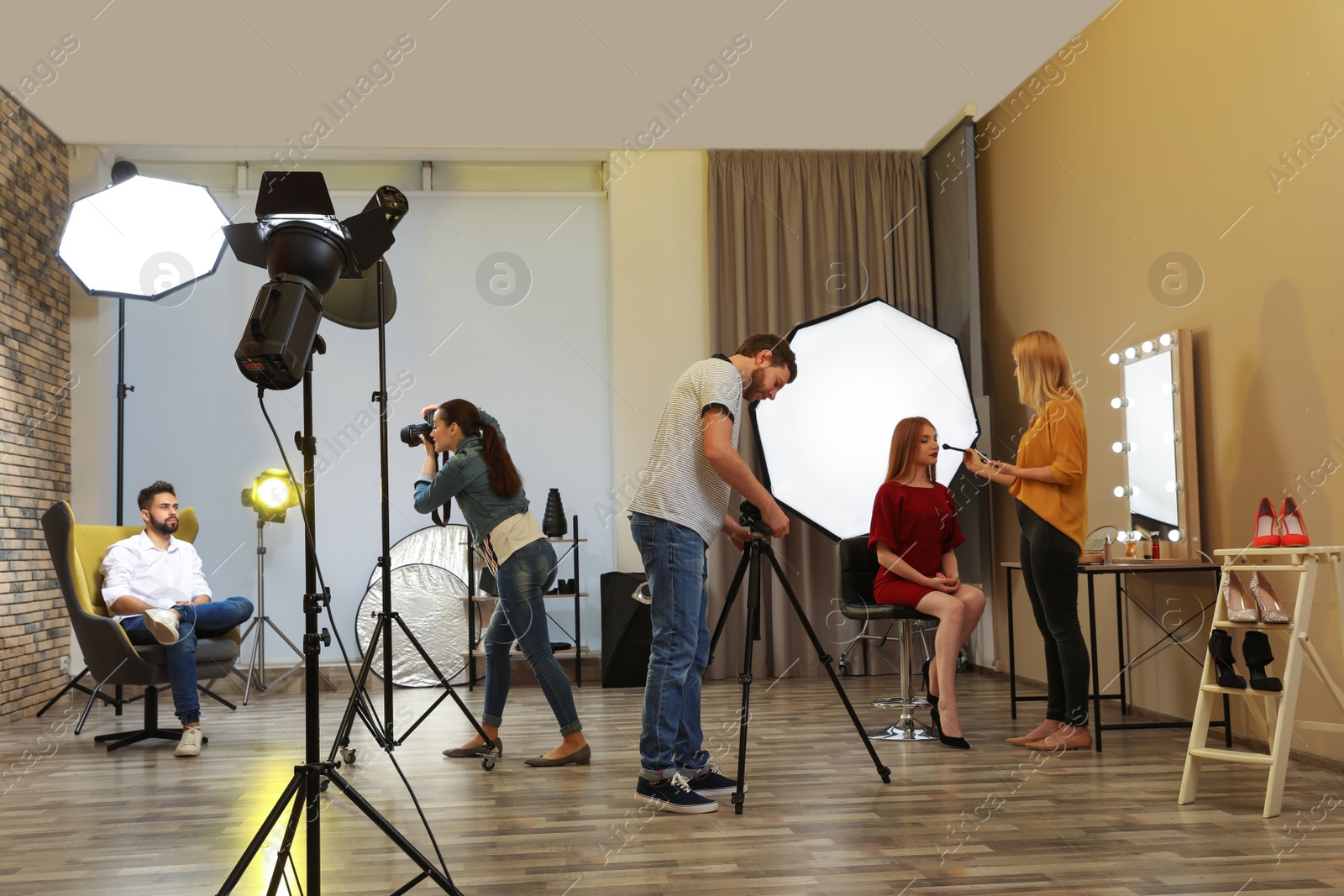 Photo of Photo studio with professional equipment and team of workers