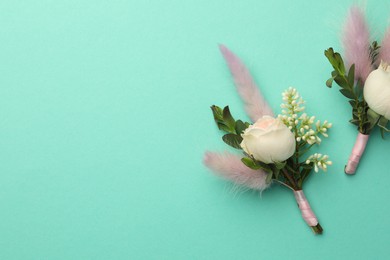 Small stylish boutonnieres on turquoise background, flat lay. Space for text