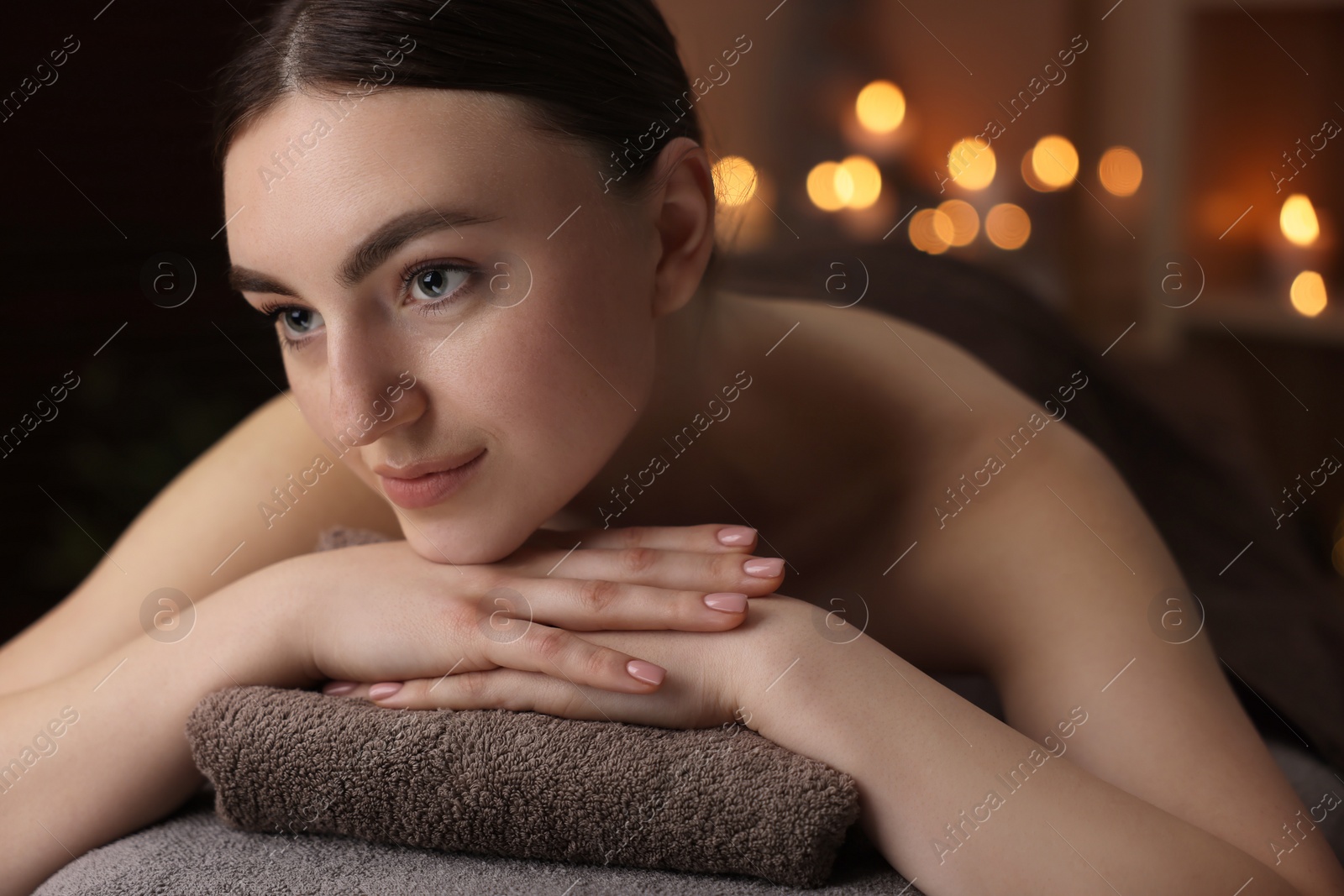 Photo of Spa therapy. Beautiful young woman lying on massage table in salon