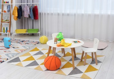 Photo of Child`s playroom with different toys and modern furniture. Stylish kindergarten interior