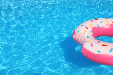 Photo of Inflatable ring floating in swimming pool on sunny day. Space for text