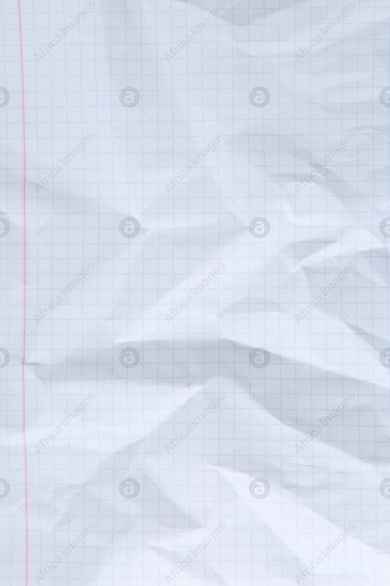 Photo of Crumpled checkered notebook sheet as background, top view