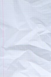 Photo of Crumpled checkered notebook sheet as background, top view