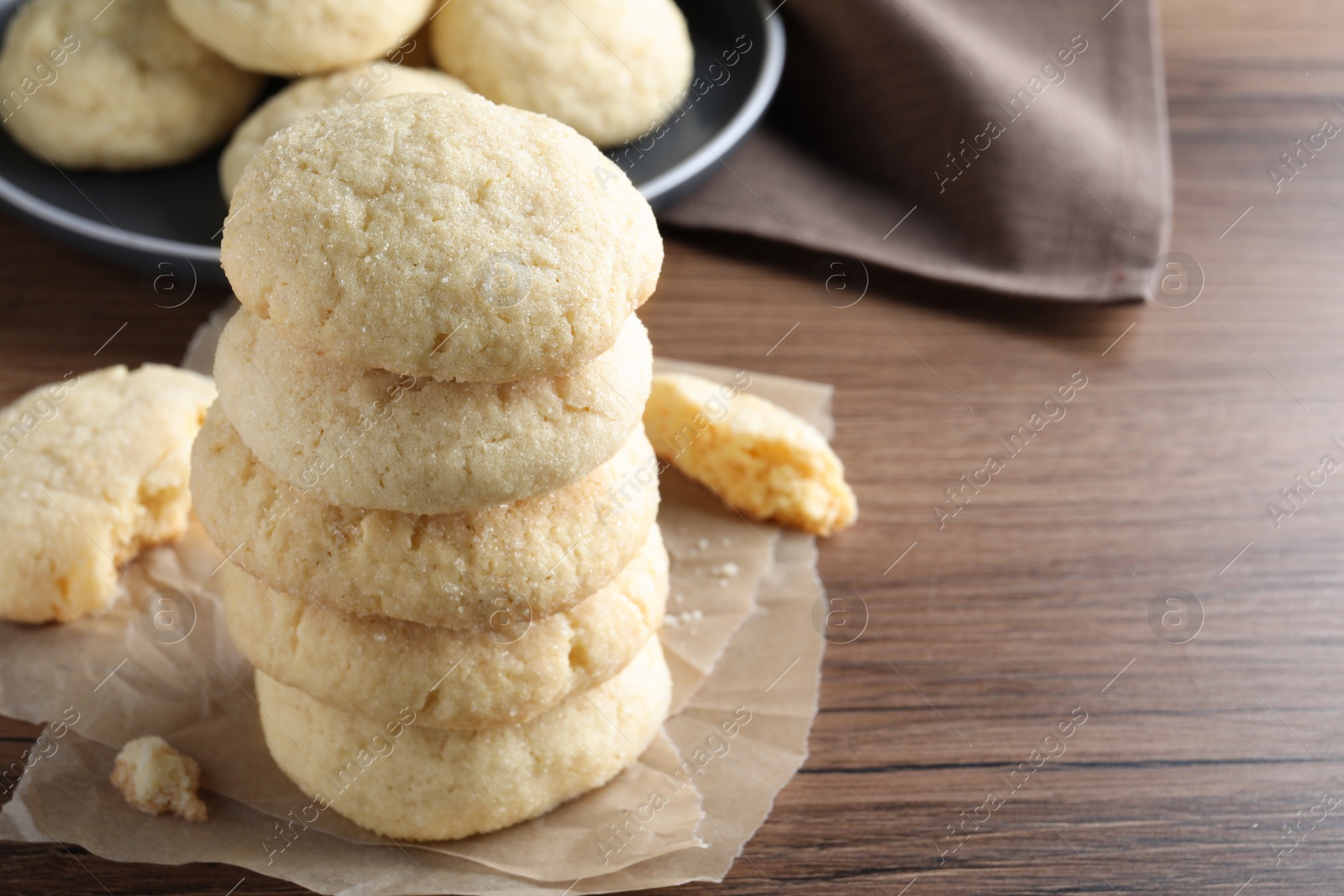 Photo of Stack of tasty sugar cookies on wooden table, closeup. Space for text