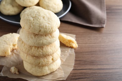 Stack of tasty sugar cookies on wooden table, closeup. Space for text