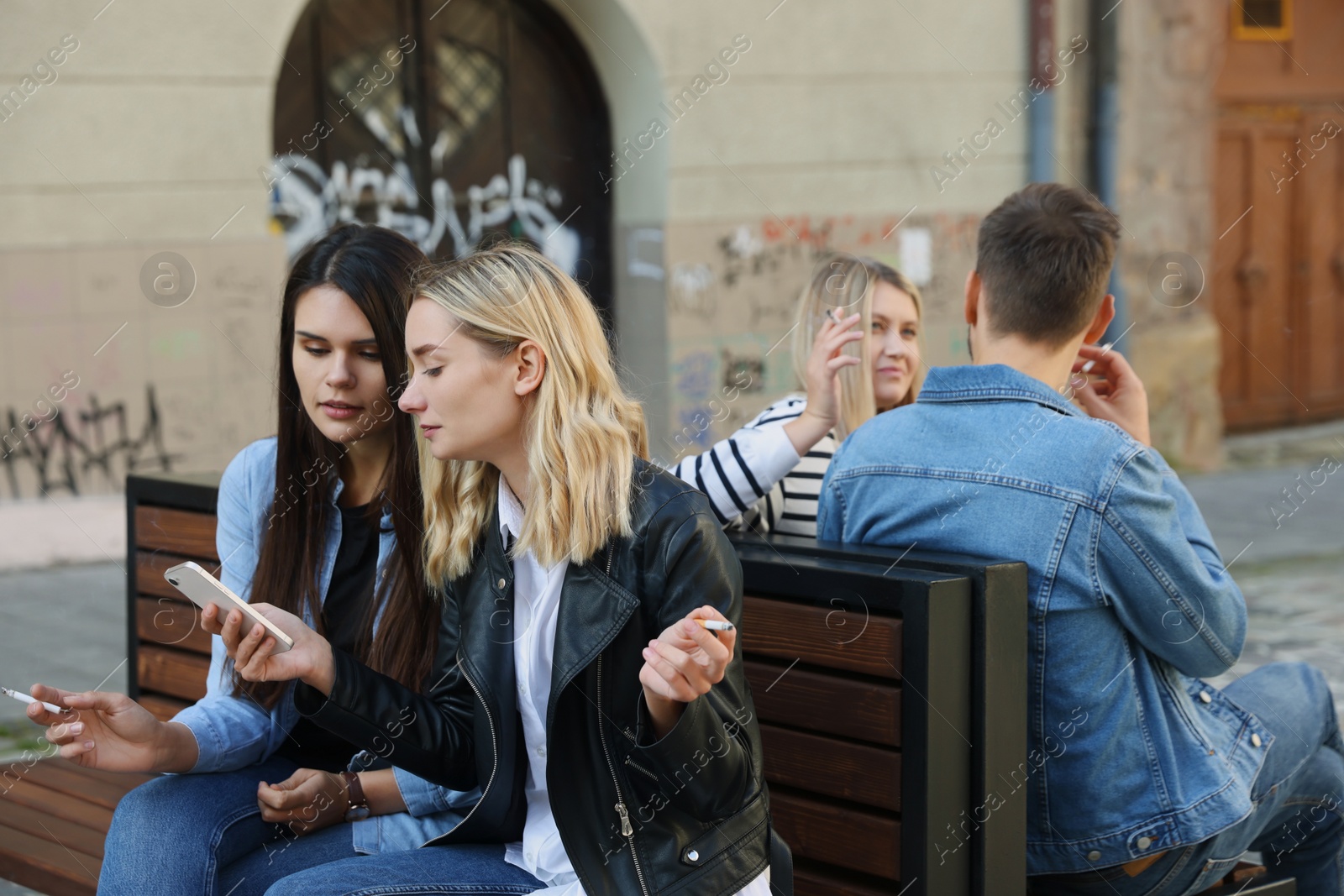 Photo of People smoking cigarettes at public place outdoors