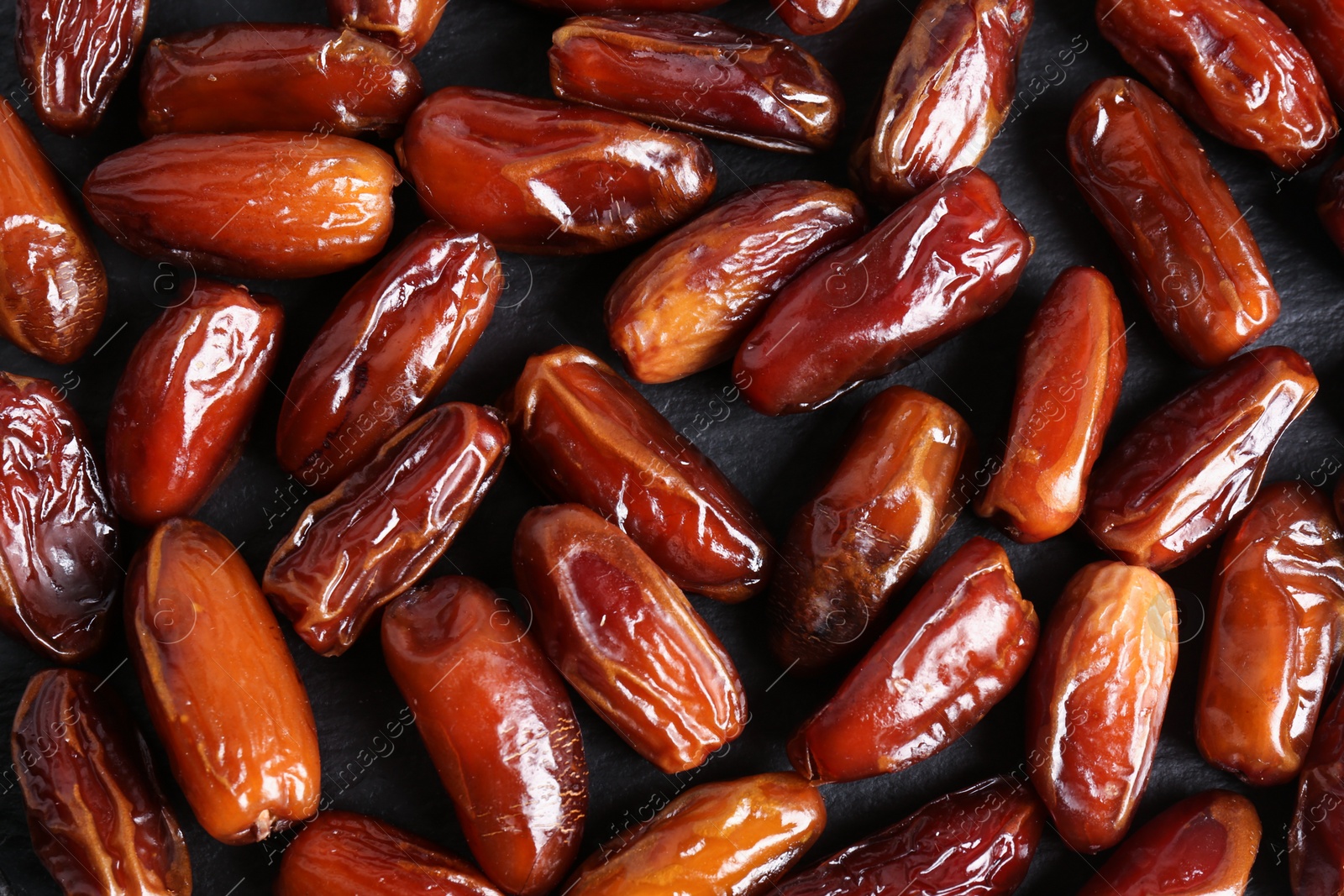 Photo of Many sweet dried dates on dark grey background, flat lay
