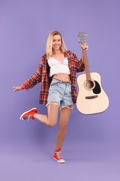 Photo of Happy hippie woman with guitar on purple background