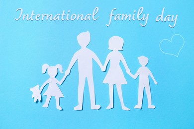 Image of Paper figures of parents and their children on light blue background, top view. Happy Family Day