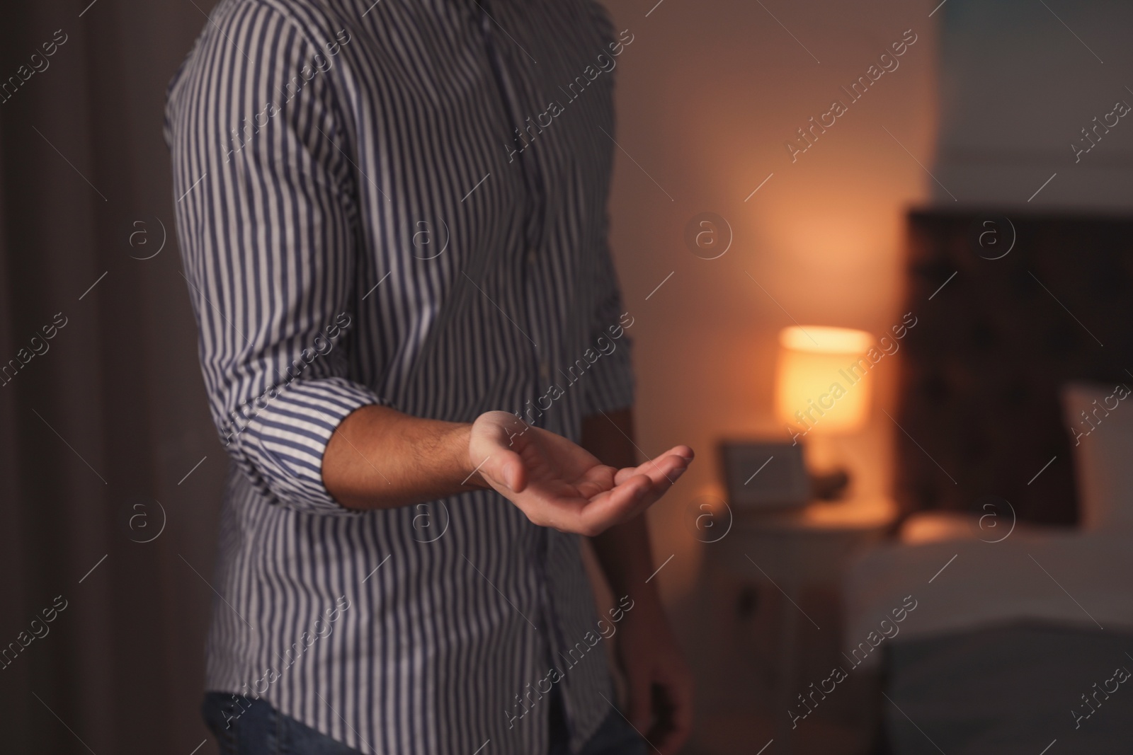 Photo of Man offering helping hand on blurred background, closeup. Space for text