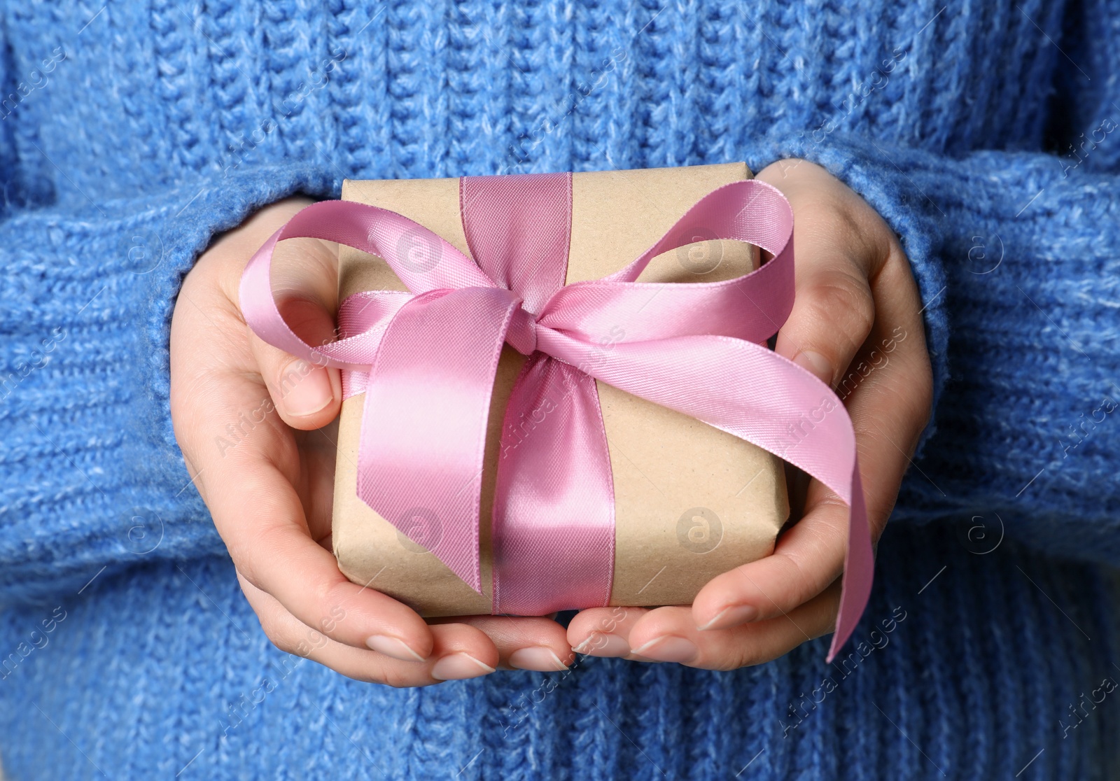 Photo of Woman holding gift box with pink bow, closeup