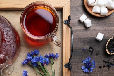 Photo of Flat lay composition with tea and cornflowers on wooden table