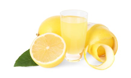 Photo of Shot glass with tasty limoncello liqueur, lemons and green leaf isolated on white