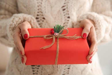 Photo of Woman holding red Christmas gift box, closeup